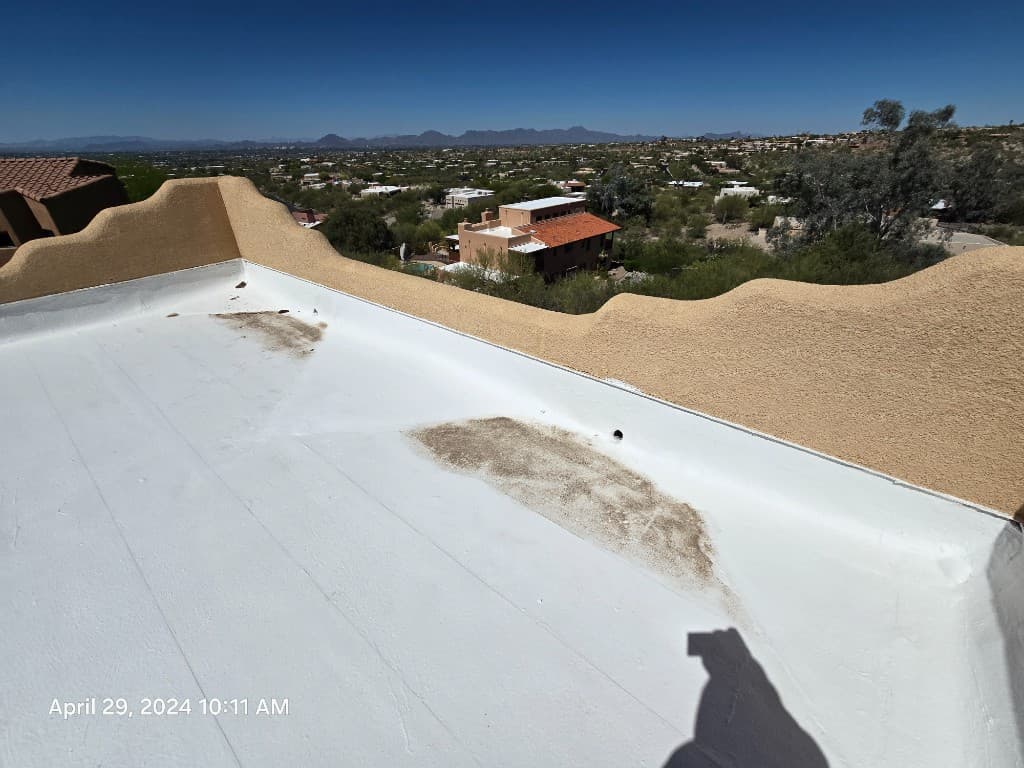 Inspector roof photo showing a small ponded-water stain on a white roof membrane